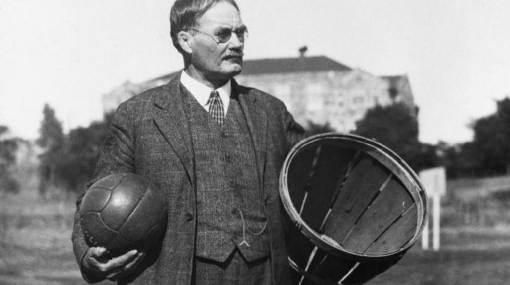 James Naismith, the inventor of basketball holding a ball and an original basket