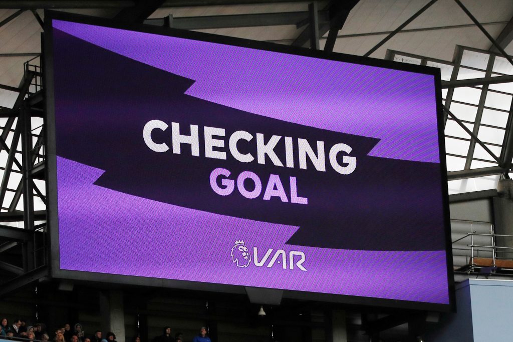 The big screen displays a VAR review message for a goal scored