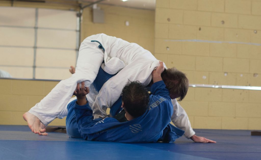 Two jujutsu fighters battling it out on a mat