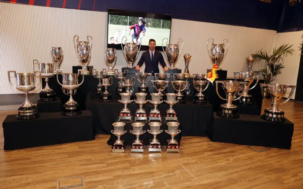 Lionel Messi with all of his trophies from across his career, showing he is one of the world's greatest athletes